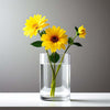 Clear glass vase with yellow sunflowers on a gray background