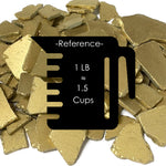 Gold-colored metal碎片 with a reference label for weight and volume.