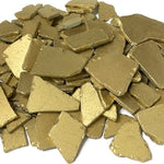 Pile of gold-colored metallic pieces on a white background