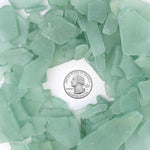 Green sea glass pieces with a U.S. quarter dollar coin in the center