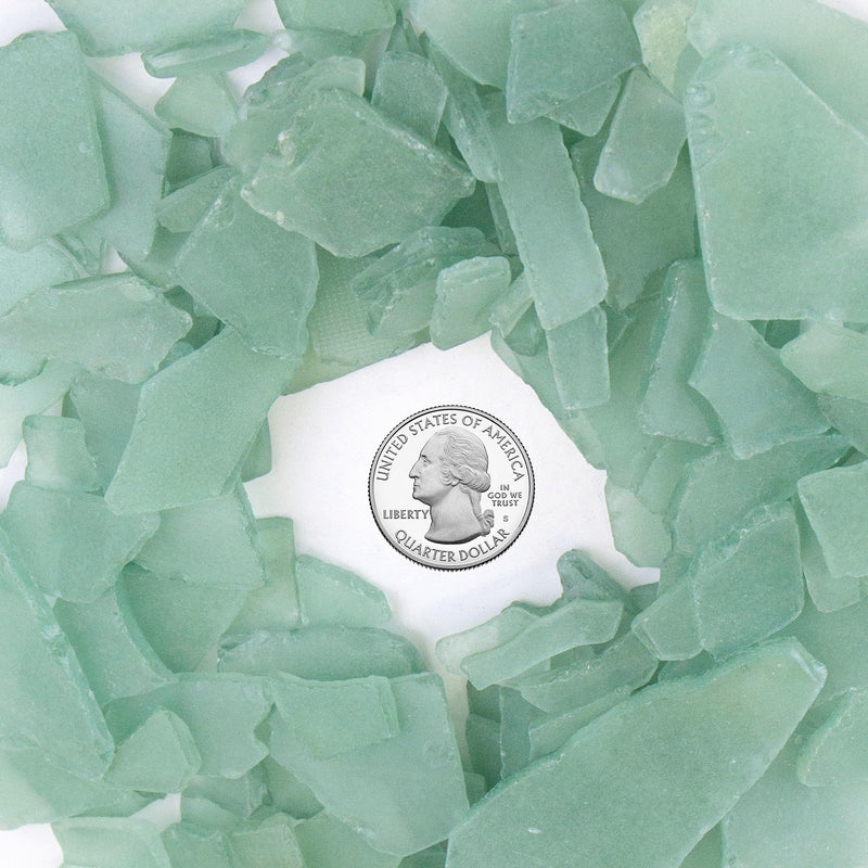 Green sea glass pieces with a U.S. quarter dollar coin in the center
