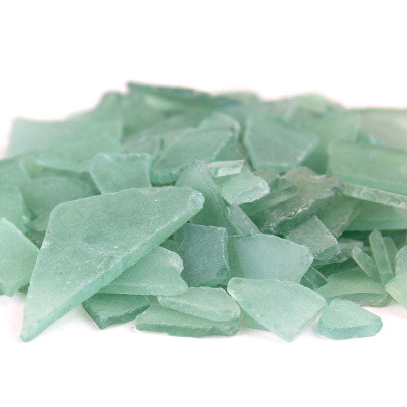 Green sea glass pieces on a white background
