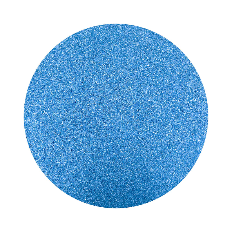 Blue colored sand arranged in a circular shape on a white background