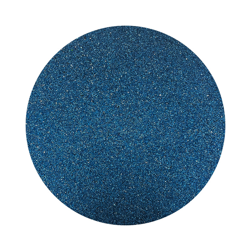 Navy Blue colored sand arranged in a circular shape on a white background