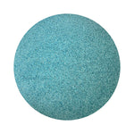 Sea Blue colored sand arranged in a circular shape on a white background