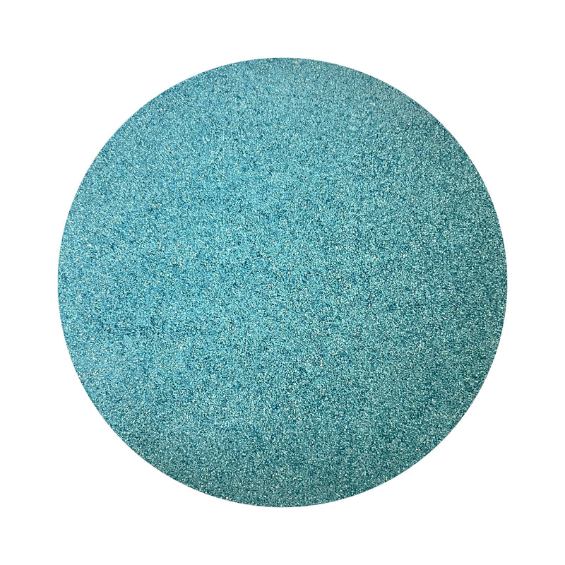 Sea Blue colored sand arranged in a circular shape on a white background