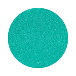 Teal Blue colored sand arranged in a circular shape on a white background