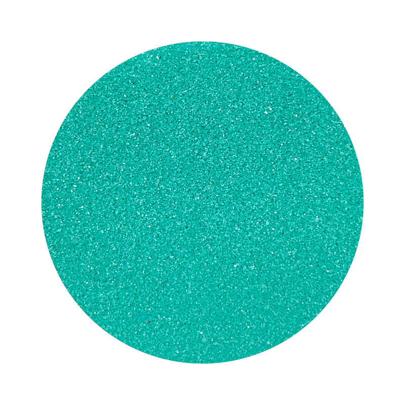 Teal Blue colored sand arranged in a circular shape on a white background