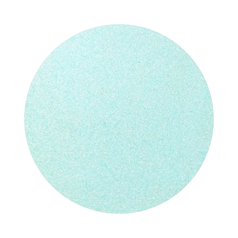 Turquoise Blue colored sand arranged in a circular shape on a white background