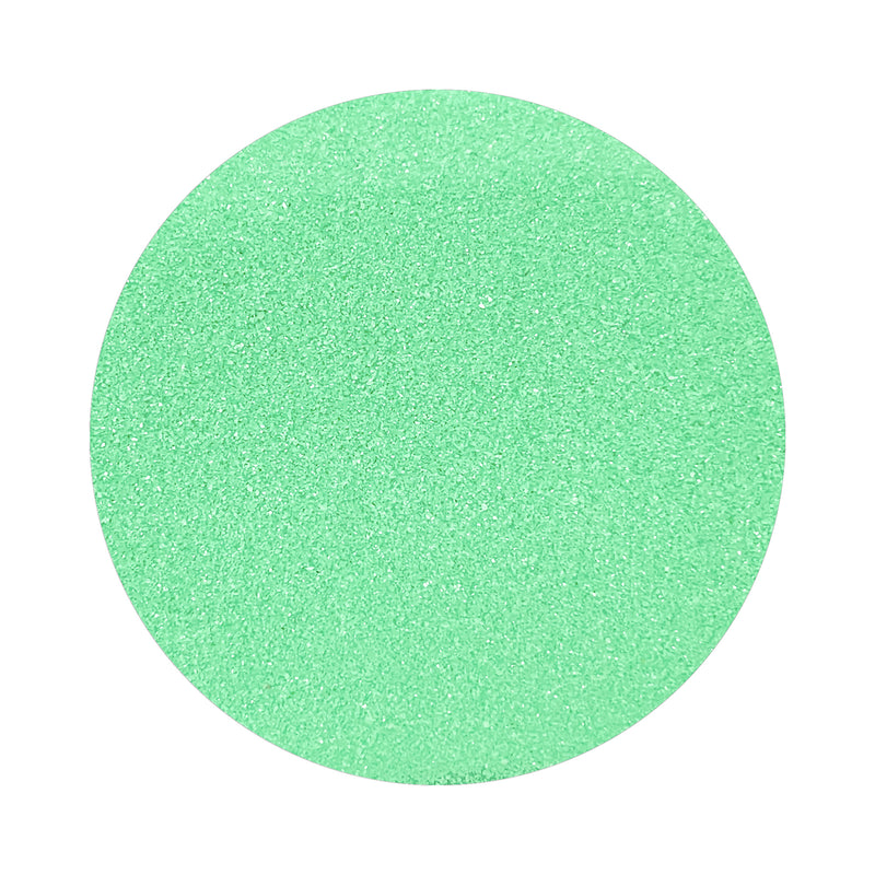 Mint Green colored sand arranged in a circular shape on a white background
