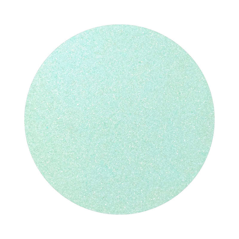 Mint Blue colored sand arranged in a circular shape on a white background