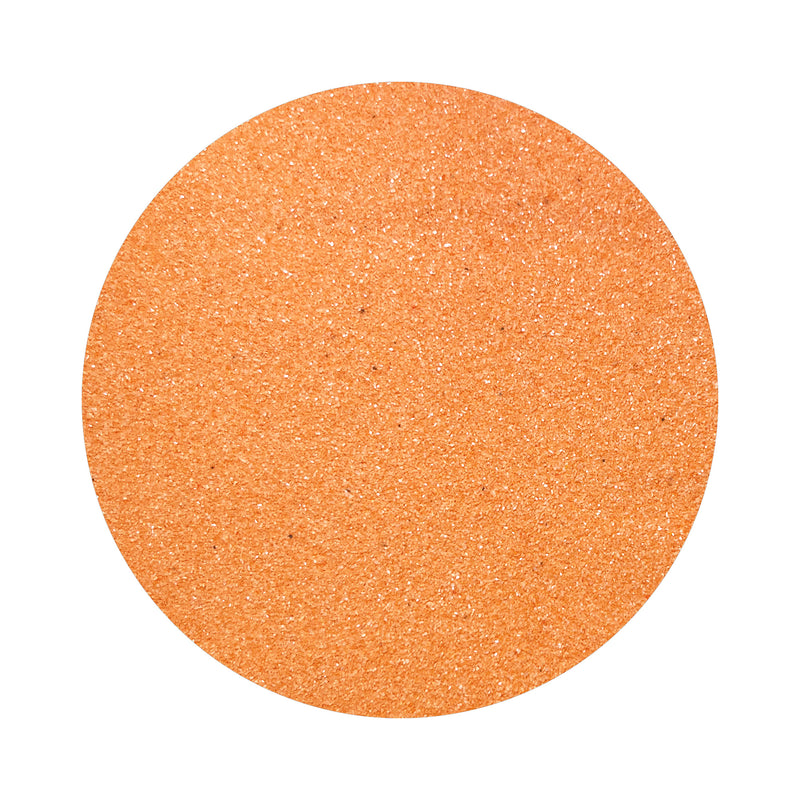 Salmon Pink colored sand arranged in a circular shape on a white background
