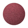 Burgundy colored sand arranged in a circular shape on a white background