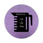 Violet Purple colored sand arranged in a circular shape on a white background colored sand in a circular shape with a measuring cup showing quantity.