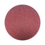 Burgundy Red colored sand arranged in a circular shape on a white background