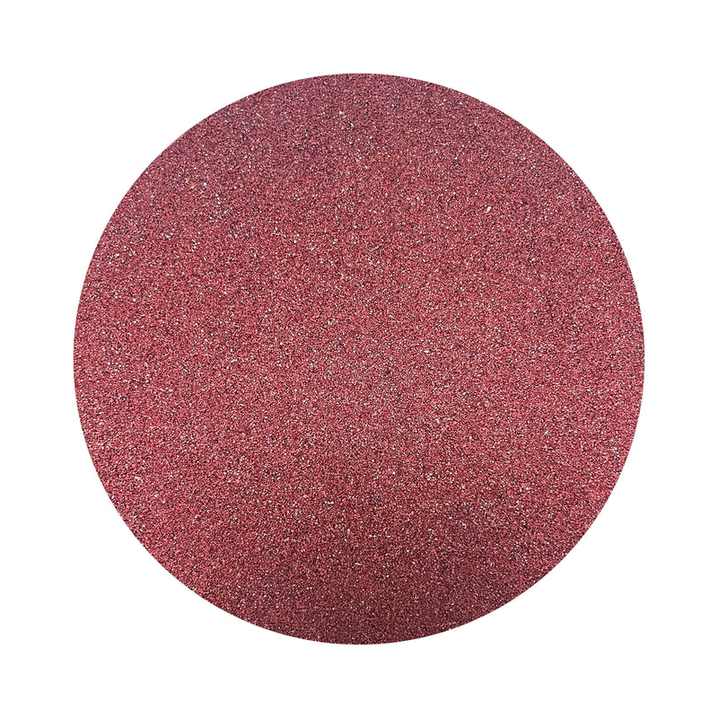 Burgundy Red colored sand arranged in a circular shape on a white background