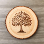 Wooden coaster with a tree engraving on a wooden surface