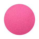 Fuchsia colored sand arranged in a circular shape on a white background
