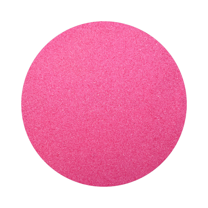 Fuchsia colored sand arranged in a circular shape on a white background
