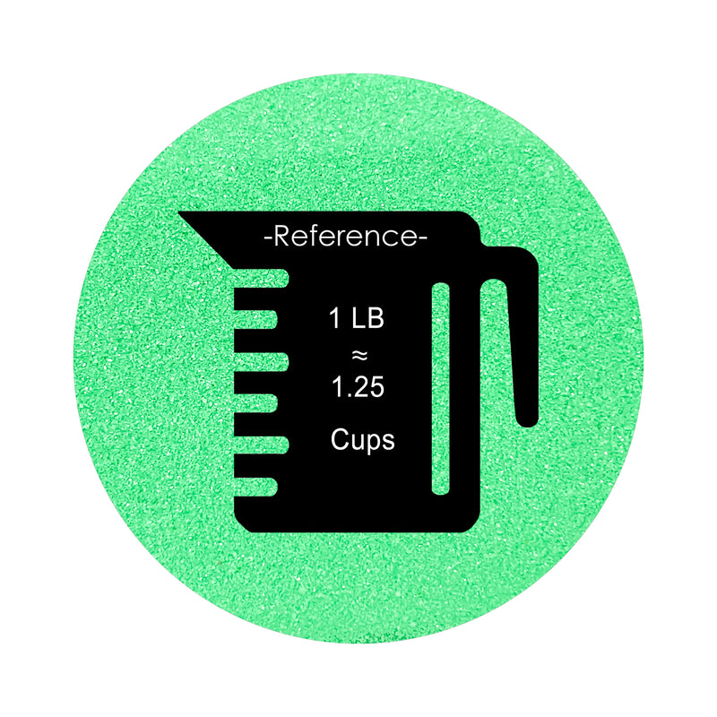 Green colored sand arranged in a circular shape on a white background colored sand in a circular shape with a measuring cup showing quantity.