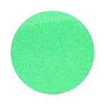 Green colored sand arranged in a circular shape on a white background