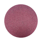 Wine colored sand arranged in a circular shape on a white background