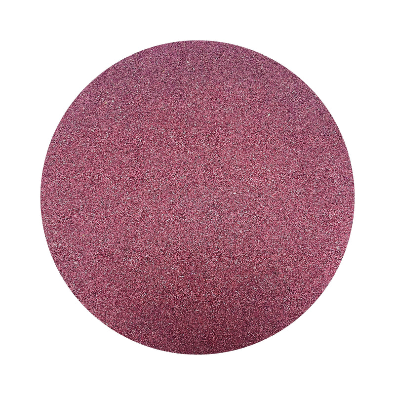 Wine colored sand arranged in a circular shape on a white background