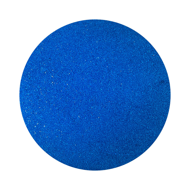 Royal Blue colored sand arranged in a circular shape on a white background