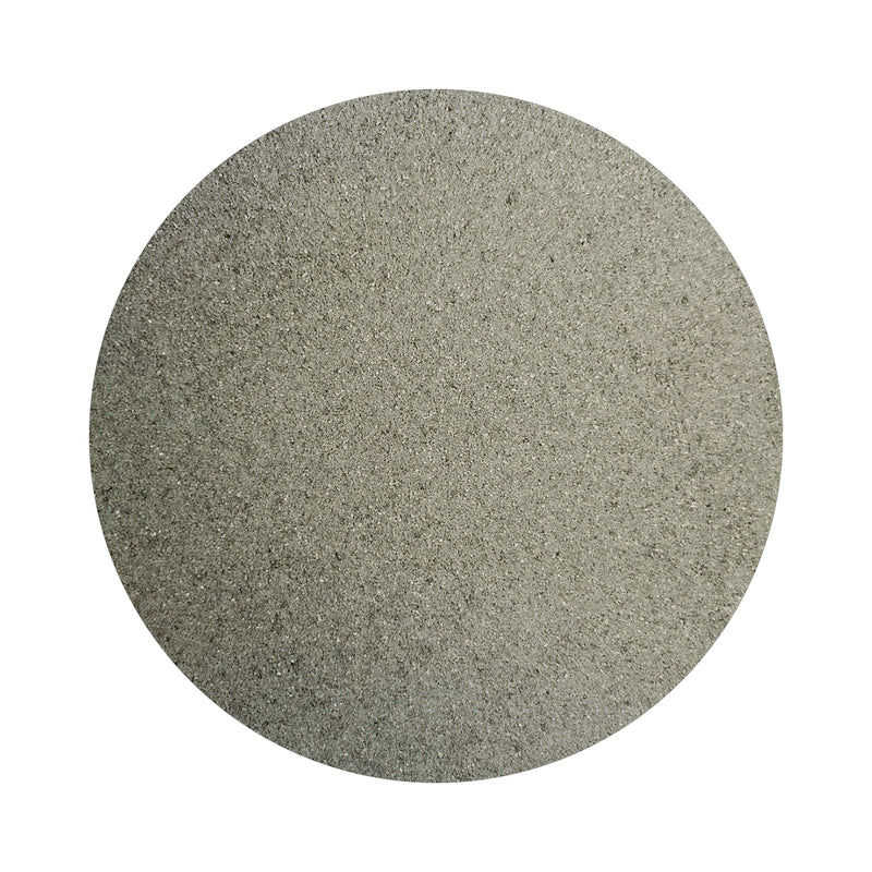 Gray colored sand arranged in a circular shape on a white background